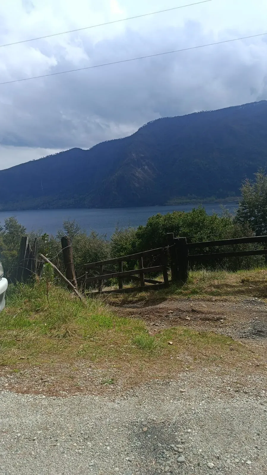 Lago Colico y cerros desde el acceso al terreno, con cerco de madera